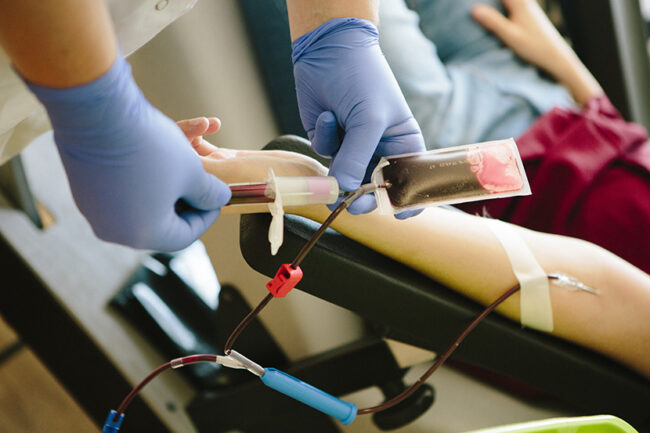 young woman get prepared by a nurse for blood donation