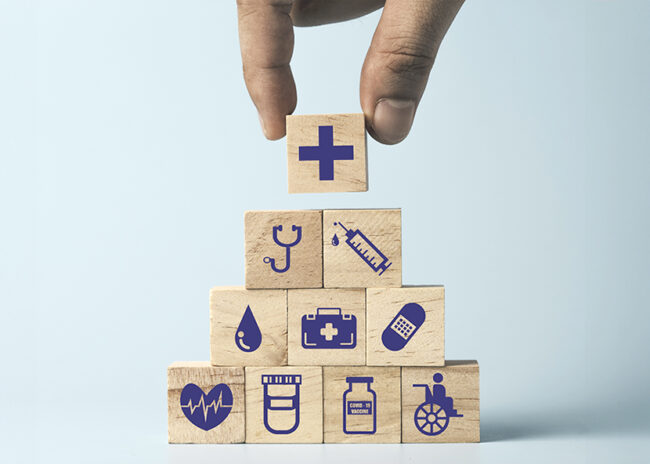 Hand putting Wooden stacking with healthcare medical and hospital icons on table , Health and insurance concept.