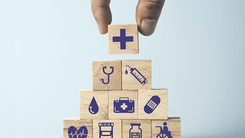 Hand putting Wooden stacking with healthcare medical and hospital icons on table , Health and insurance concept.