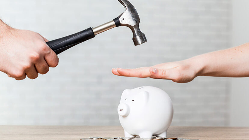 hammer raised above a white piggy bank