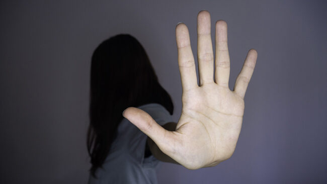 Painful woman saying stop with her hand – Stop abusing, human trafficking, stop violence against women,stop women abuse.