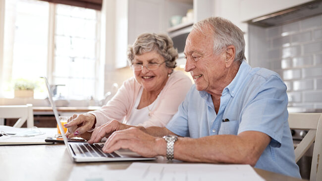 Shot of an elderly couple using a laptop together in the kitchen at home
