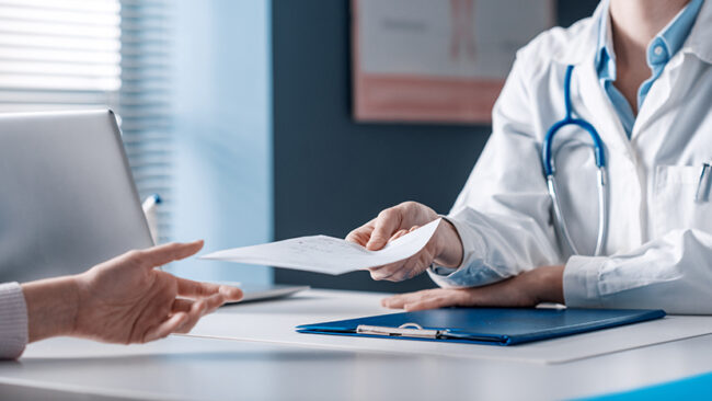 Doctor giving a prescription to a patient