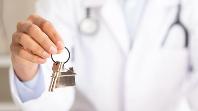 Doctor holding house key and coin